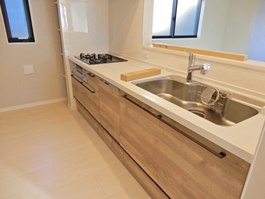 D号棟のI型キッチン♪キッチン横に収納棚があり、棚はキッチン側だけではなく背面（リビング側）にも設置されており、空間の有効利用がなされております。